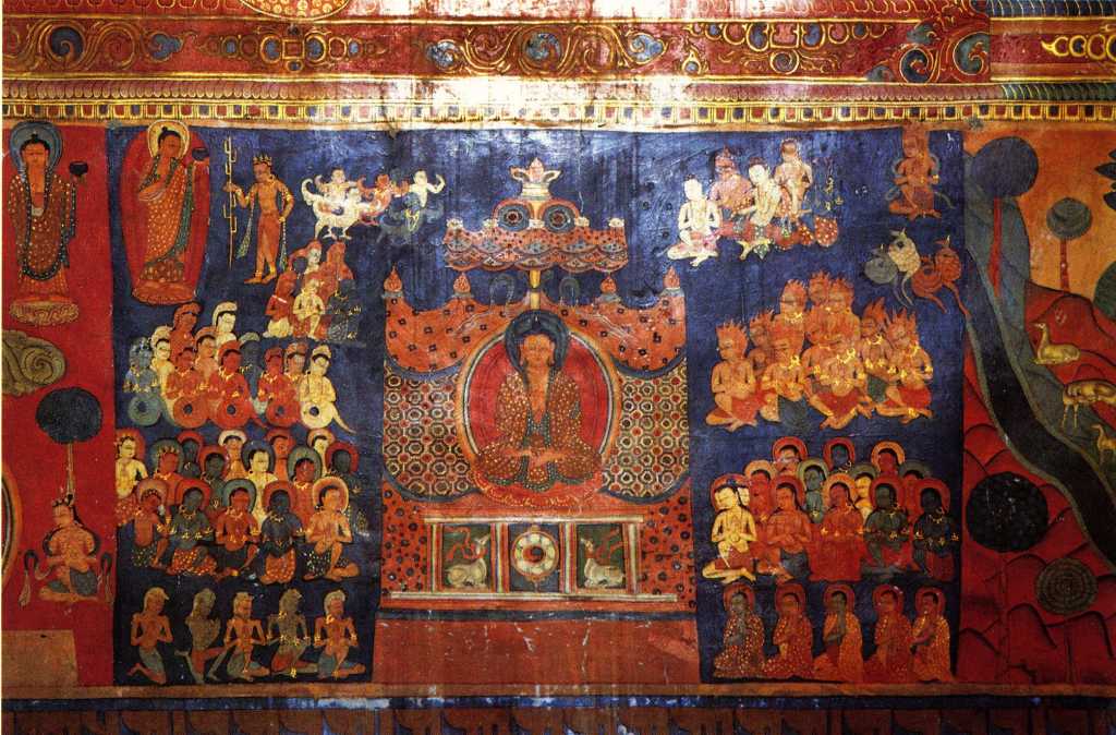 Tibet Guge 07 Tsaparang Red Temple 10 Band Life of Buddha � nowhere has it (the life of Buddha) been represented with so many details, with such a richness of scenes and with such a movement as here at Tsaparang. These frescoes have to be singled out as works of art. � Still above, the Buddha standing with the pindapatra in his right hand, indicates his resolution to deliver the famous first sermon. He starts walking towards Sarnath and en route meets the ajivaka Upagana, here represented with the ascetic stick: it is to him that he reveals his proposal to go to Banares to preach the law. The scene of preaching is, in fact, represented on the following panel. The Buddha sits on a throne covered by a rich canopy, with his hands in the attitude of the preaching mudra. On the basement of the throne are the traditional symbols of this culminating moment in the life of the Saint of the Sakyas namely, in the middle, the wheel representing, according to ancient symbolism, the first preaching; and on both sides two deer, reminding of the park actually called �the Deer Park�, where the famous ceremony was pronounced. Around him, in the act of devoted concentration and kneeling as a mark of homage, is a numerous crowd of every kind of creature: garuda above, nagas slightly below, gandharva and kinnaras, and then deities guided by Brahma and ascetics. The five emaciated yogins praying in the foreground possibly reproduce his first disciples. - Giuseppe Tucci: The Temples of Western Tibet and their Artistic Symbolism (1935). Photo - Weyer/Aschoff: Tsaparang, Tibets Grosses Geheimnis.
